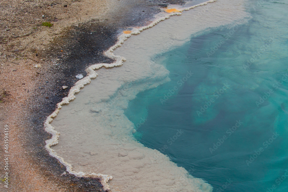 Edge of turquoise pool of hot springs in Yellowstone National Park
