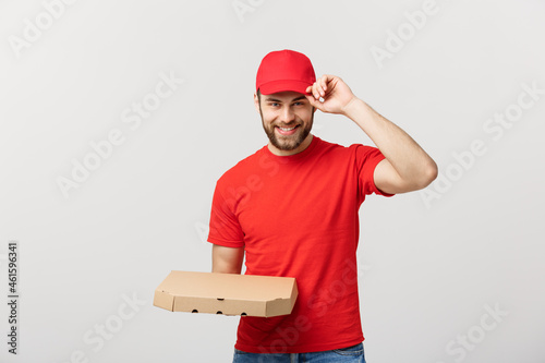 Delivery Concept: Young haapy caucasian Handsome Pizza delivery man holding pizza boxes isolated over grey background photo