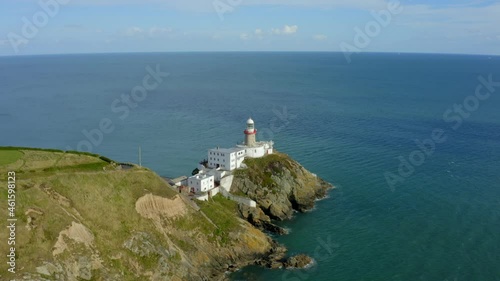 Baily Lighthouse, Howth, Dublin, Ireland, September 2021. Drone slowly orbits from Howth head at the northwest while gradually descending with the view east across the Irish sea in the background. photo