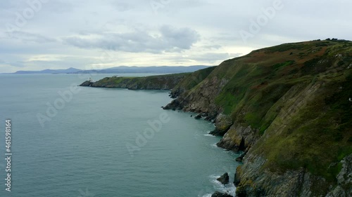 Howth, Dublin, Ireland, September 2021. Drone slowly pushes south along the cliffs at Howth Head towards the Baily Lighthouse with Dún Laoghaire and Killiney in the distance. photo
