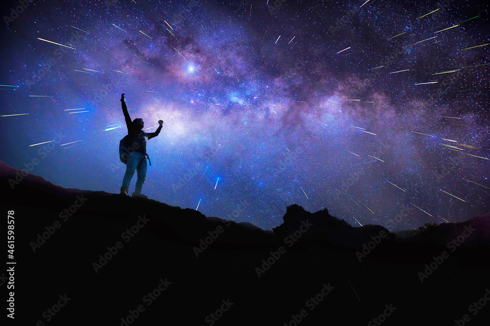 Landscape with Milky Way. Night sky with stars and silhouette of a standing happy man on the mountain, Success or winner, leader concept. High iso with Noise.