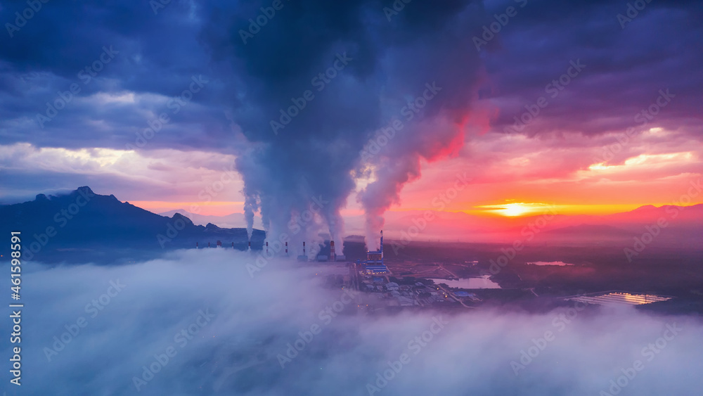 Fototapeta premium Aerial view coal power plant station in the morning mist, the morning sun rises. coal power plant and environment concept. Coal and steam. Mae Moh, Lampang, Thailand.