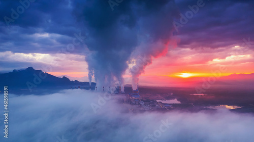 Aerial view coal power plant station in the morning mist, the morning sun rises. coal power plant and environment concept. Coal and steam. Mae Moh, Lampang, Thailand.