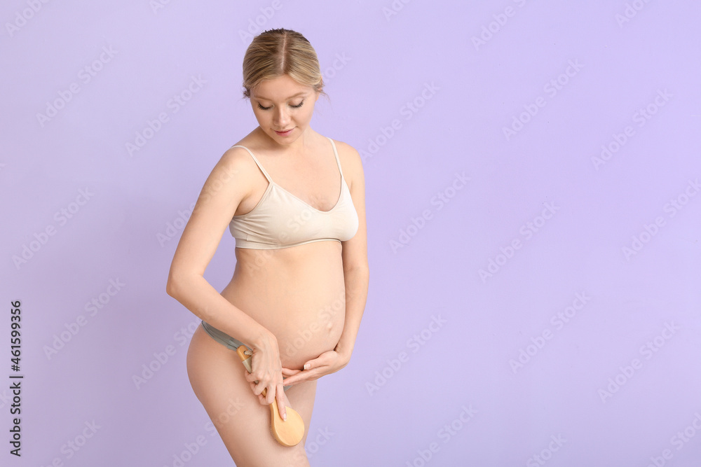 Beautiful pregnant young woman with massage brush on color background Beautiful pregnant young woman with massage brush on color background