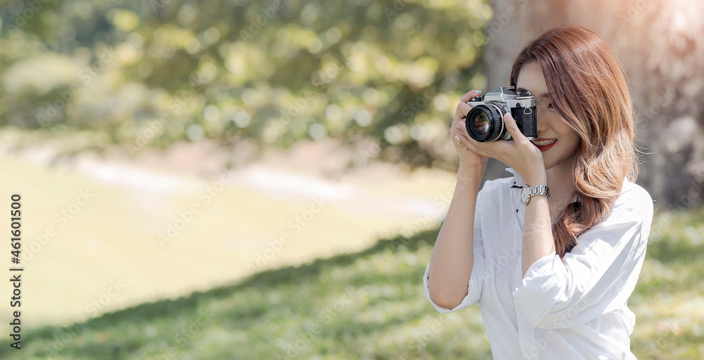 Beautiful smiley asian woman using camera outdoors under the sunlight. Beautiful smiley asian woman using camera outdoors under the sunlight.