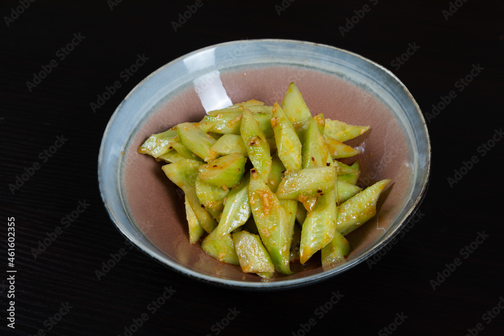 Salad with chopped cucumbers in garlic sauce on a black background Salad with chopped cucumbers in garlic sauce on a black background