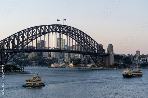 city harbour bridge with ferries at sunset
