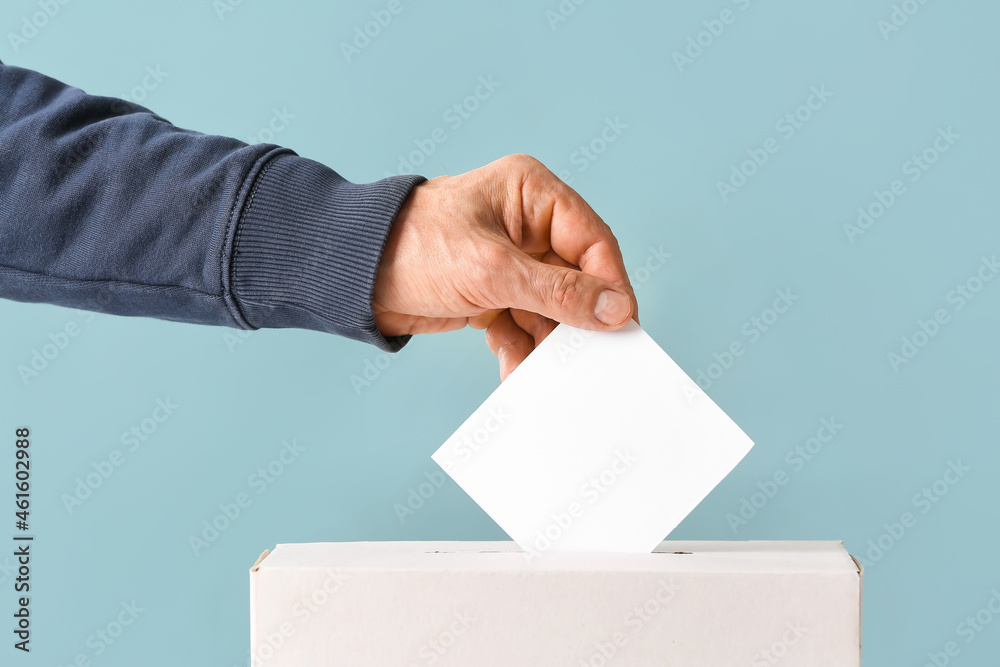 Voting man near ballot box on color background Voting man near ballot box on color background