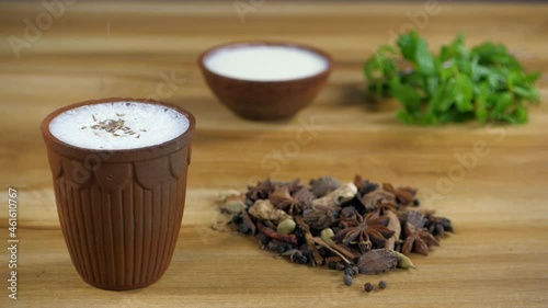 Refreshing buttermilk / Chaas being seasoned with cumin seeds from the top. Fresh yogurt  popular Indian spices  and green mint leaves kept together - heart health  weight loss  boost immunity  hig... photo