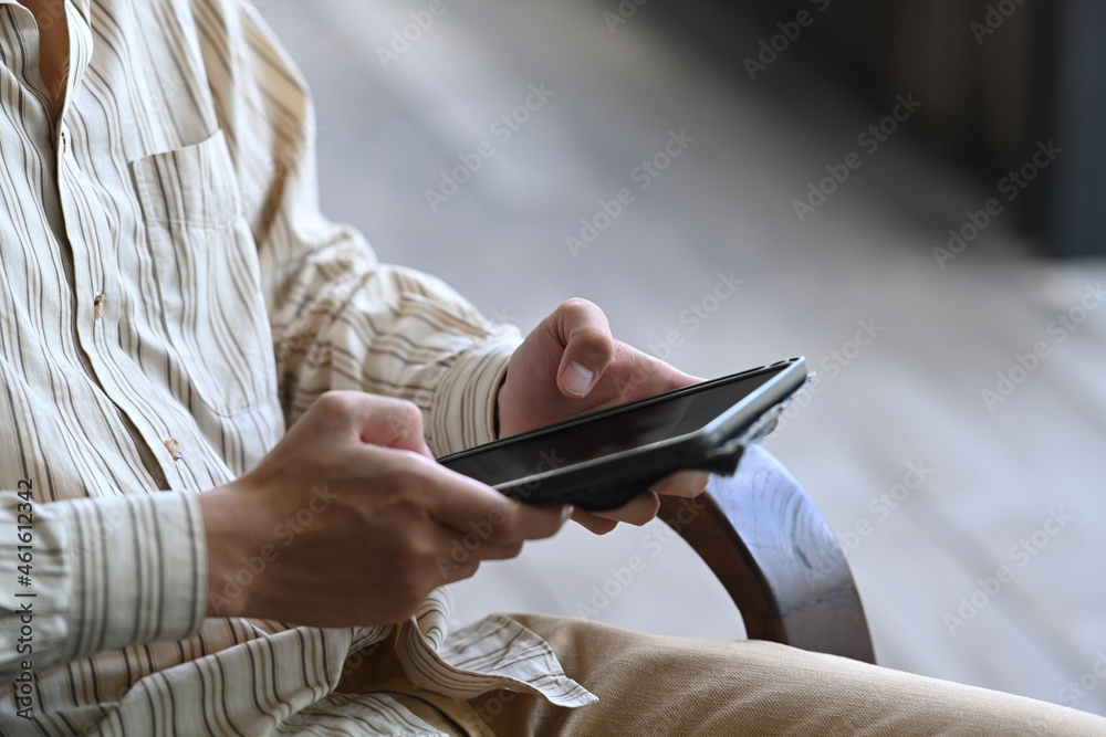 Businessman checking email on digital tablet.