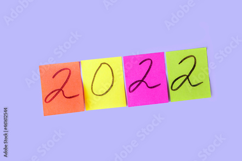 Inscription numbers 2022 on colorful stickers. New year concept. Sticky note, copy space for text.