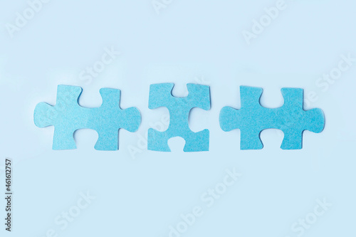 Blue jigsaw puzzle pieces on yellow background. Teamwork logical thinking. Concept of solutions, mission, success, goals, cooperation and partnership. Copy space for text