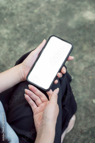 Cropped shot of woman hand holding blank screen smartphone, vertical view.