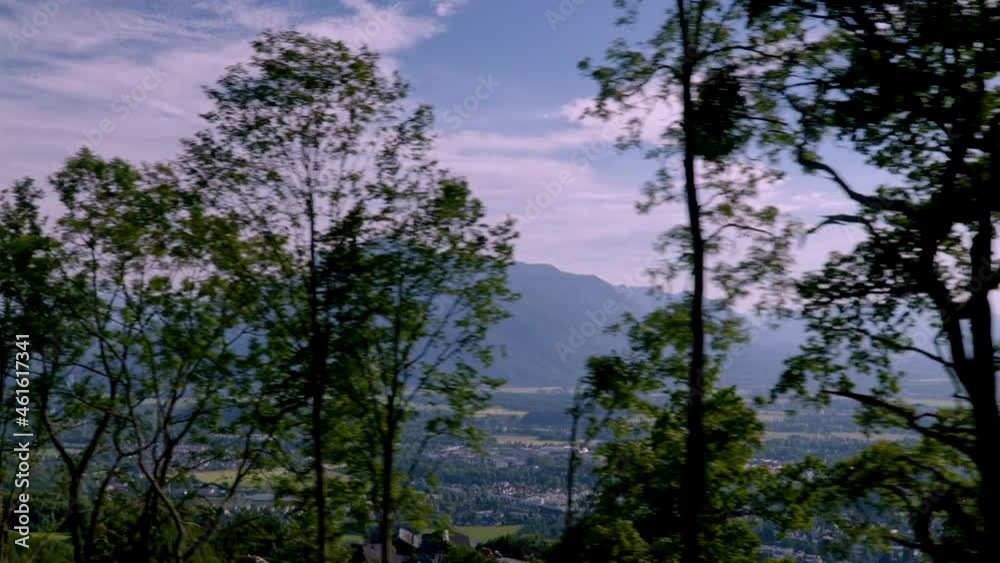side shot of the mountains of Austria where you can see the snow-capped mountains in the background while recording from a car and passing the trees in the foreground that give way to the mountains side shot of the mountains of Austria where you can see the snow-capped mountains in the background while recording from a car and passing the trees in the foreground that give way to the mountains