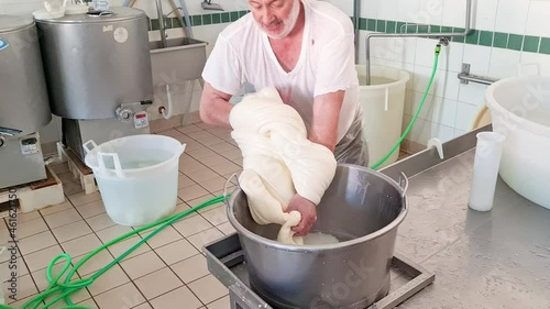 Cheesemaker making  stretched curd  to produce mozzarella and caciocavallo in cheese factory in Basilicata, Italy 