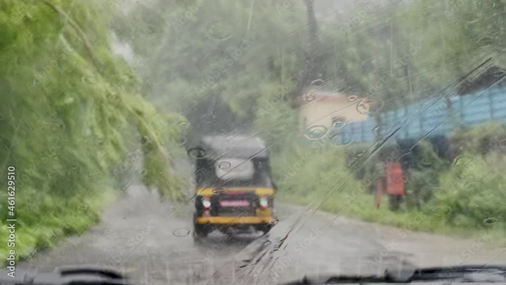 Wipers Wiping Blurry Windshield Glass Wet With Raindrops While Driving On The Street On A Stormy Weather. POV