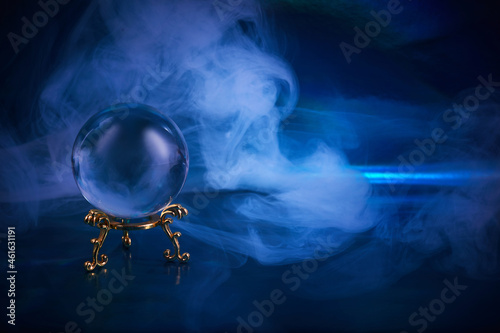 Foto Crystal ball in a dark blue smoky background