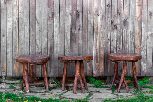 three wooden chairs  made in the old style  near a wooden wall