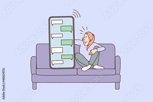 Girl sit on couch text message on huge smartphone gadget. Woman relax at sofa communicate online on cellphone on social media. Tiny people concept. Technology, communication. Vector illustration. 