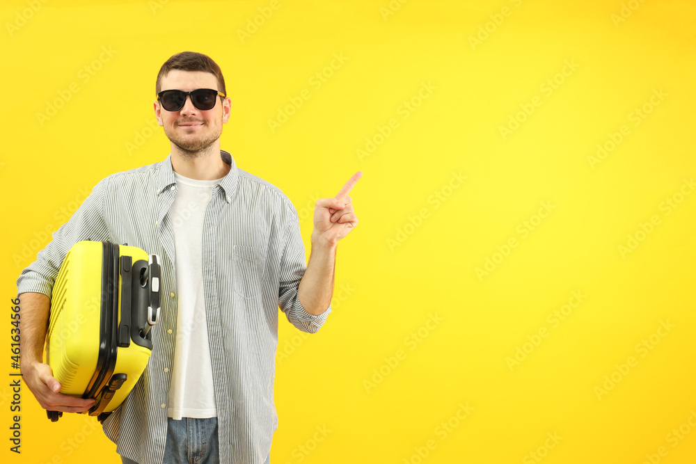 Traveling concept with young man on yellow background, space for text Traveling concept with young man on yellow background, space for text