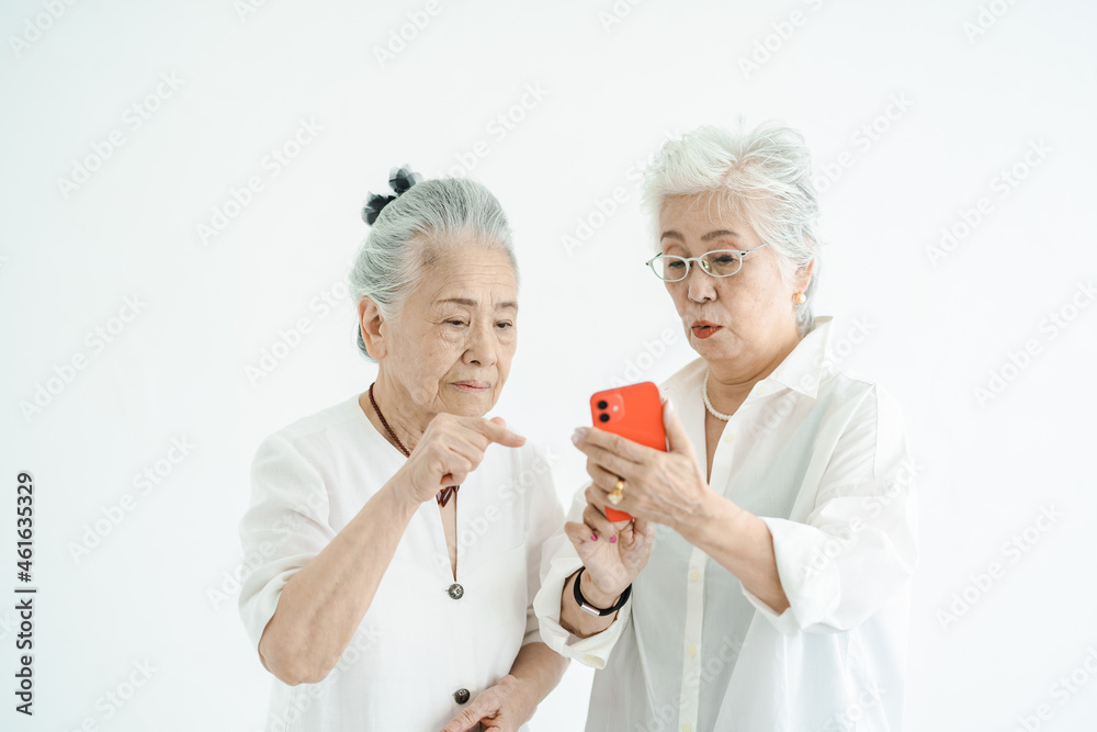 試行錯誤しながらスマートフォンを操作するシニア女性たち