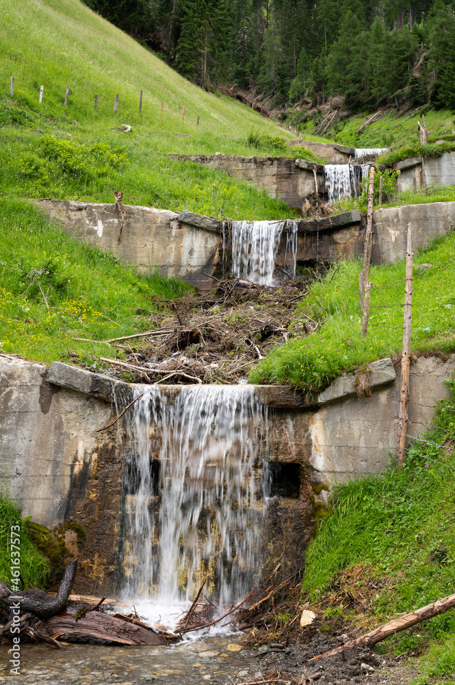 Obraz premium Small river cascades in the alps on a cloudy day in summer