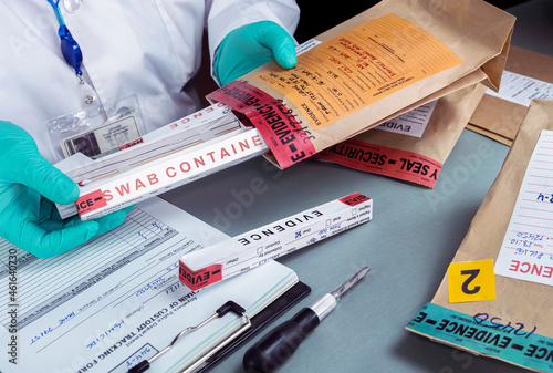 Fotografie Forensic police check files against evidence in crime lab, conceptual image