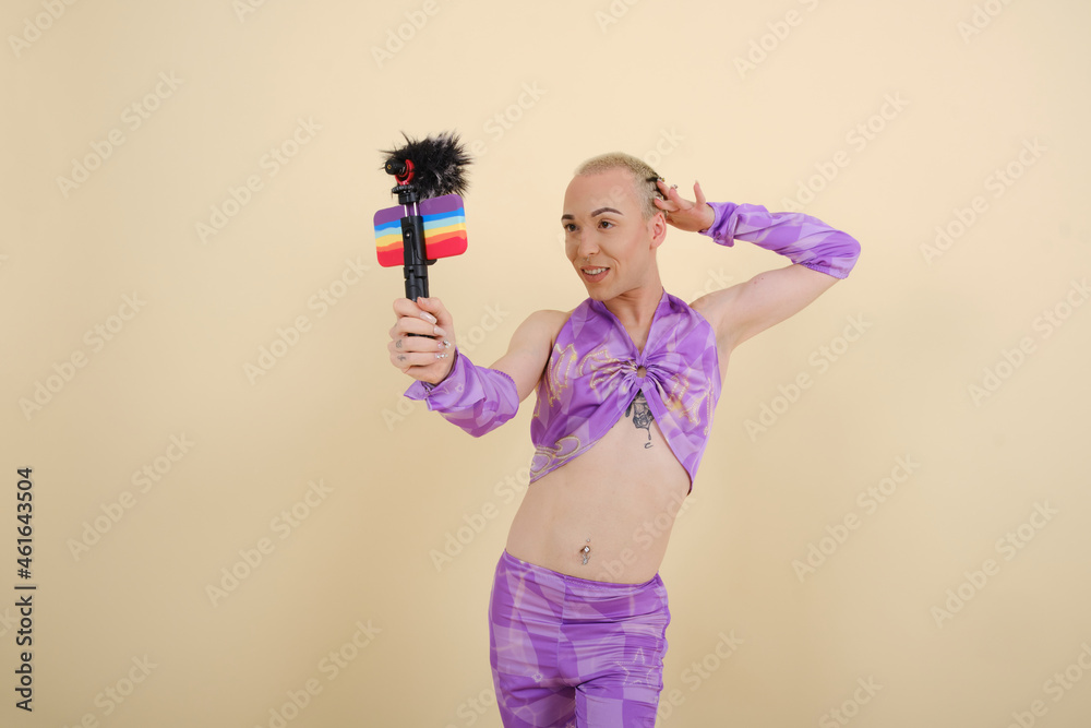 Non-binary person creating content for social media while making a video with a smartphone. Non-binary person creating content for social media while making a video with a smartphone.