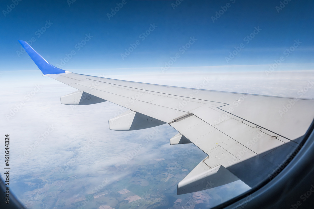 Obraz premium aircraft wing from the aircraft window overlooking the blue sky and beautiful clouds