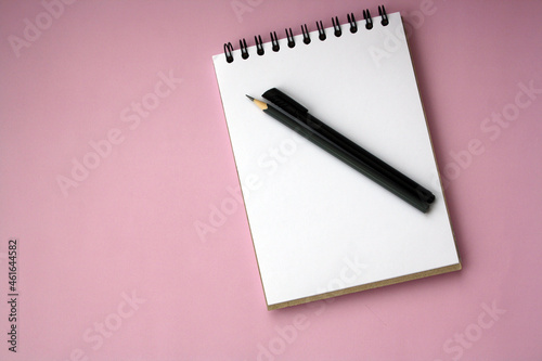 Planner layout, open blank spiral notebook for design, lettering, text, template. Pink background, pen, pencil.