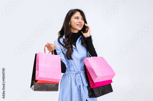 One beautiful young girl shopping while black friday sales. Model with lots of bags, colorful bright packages isolated over white studio background.