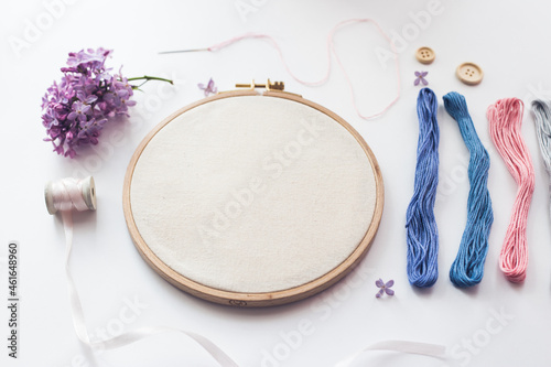 Flat lay top view photo of a mockup with embroidery hoop and llilac flowers.