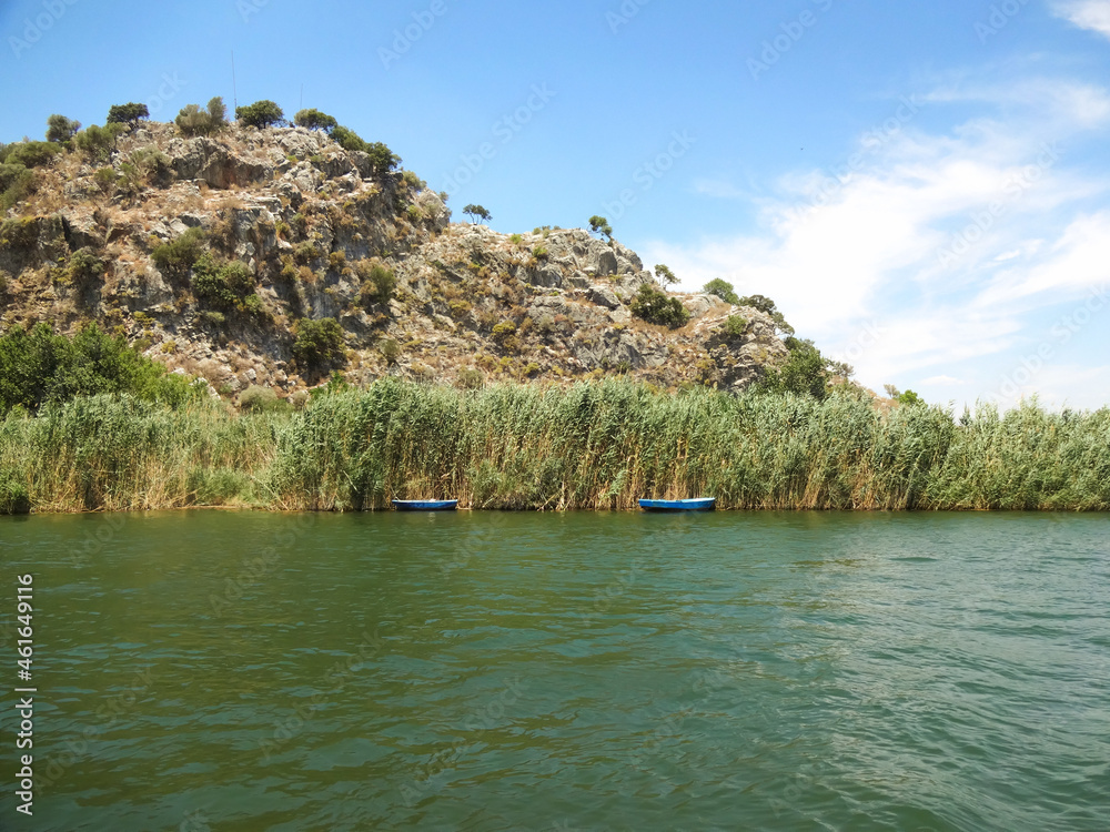View of the rocky banks of the river and fishing boats i
