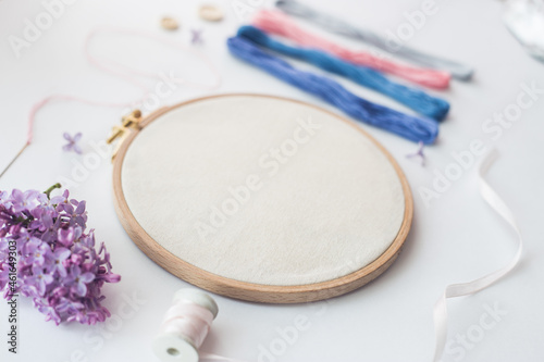 Flat lay top view photo of a mockup with embroidery hoop and llilac flowers.