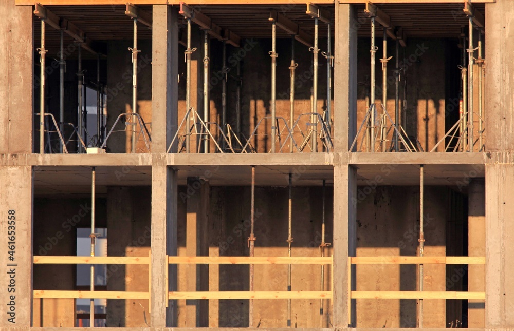 Frame and sections of a new monolithic multi-storey building. Monolithic floor formwork and supports. Telescopic concrete floor props. Construction of a modern apartment building Frame and sections of a new monolithic multi-storey building. Monolithic floor formwork and supports. Telescopic concrete floor props. Construction of a modern apartment building