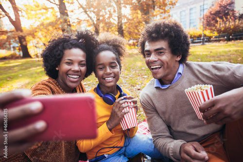 Mixed family having fun while picnicking in the park make selfie photo. photo