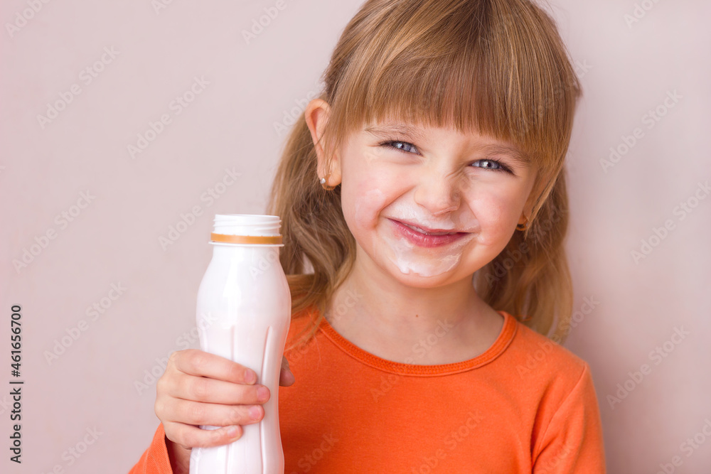 Portrait of a little beautiful girl with emotions on her face, her mouth stained with milk, holding a plastic bottle with a milk drink, yogurt or kefir, selective focus Portrait of a little beautiful girl with emotions on her face, her mouth stained with milk, holding a plastic bottle with a milk drink, yogurt or kefir, selective focus