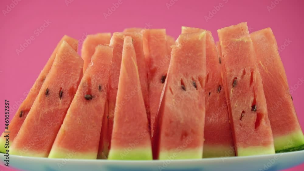 Watermelon slices rotate in front of the camera. A close-up of the watermelon pulp reflects the play of light. Watermelon slices rotate in front of the camera. A close-up of the watermelon pulp reflects the play of light.