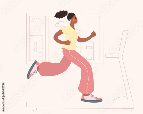 Beautiful young African-American woman running on a treadmill at home. Sports at home. Healthy lifestyle concept.