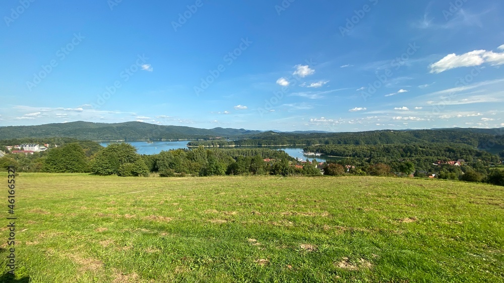 Bieszczady mountains in the vicinity of Lake Solinskie covered with forests and meadows sky blue clouds