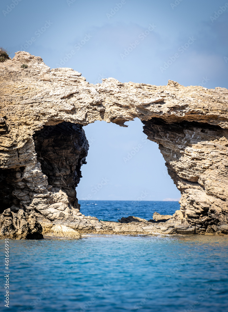 La porte de la mer avec une grotte perçante les rochers d'une petite en Grèce