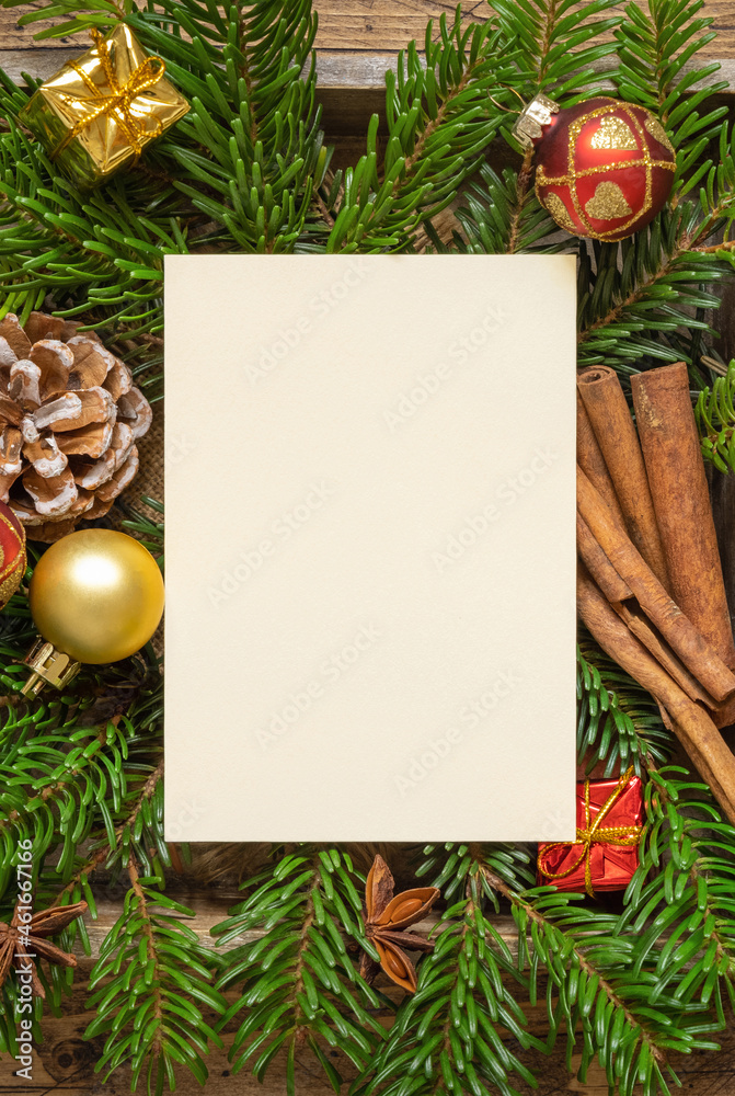 Obraz premium Christmas Composition with a blank card, fir branches and decorations on wooden table