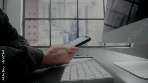 Person touches phone screen dialing number sitting at table