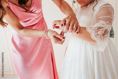 Manos poniendo reloj con vestido de primera comunión. Reloj de comunión de niña.