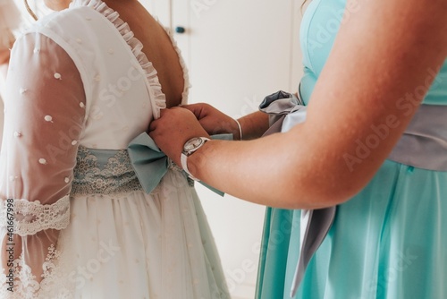 Manos con vestido de primera comunión. Vestido de comunión de niña.