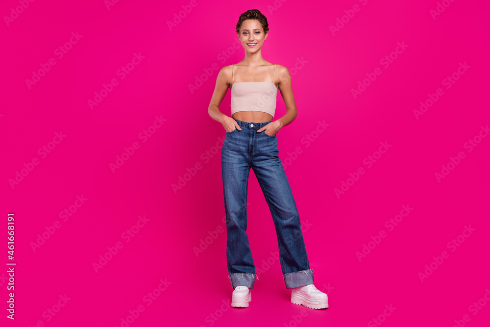 Full body photo of positive charming woman hold hands pockets good mood smile isolated on magenta color background