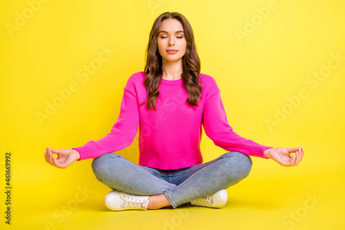 Full size photo of young attractive beautiful relaxed peaceful girl sitting floor doing yoga isolated on yellow color background