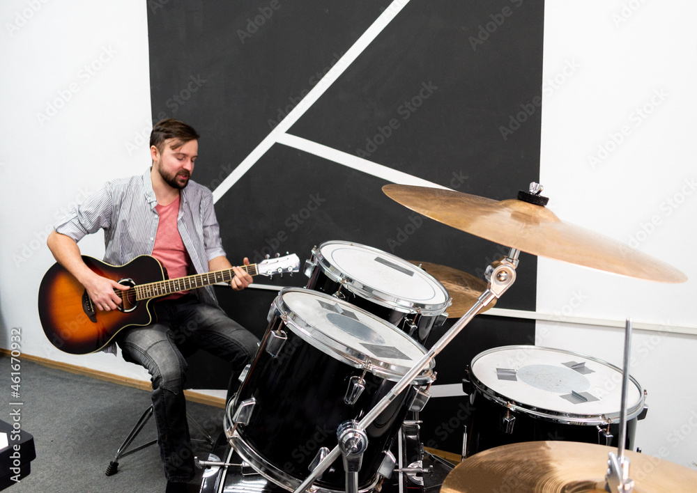 Fototapeta premium Male musician is playing music on wooden acoustic guitar, capture chords by finger.