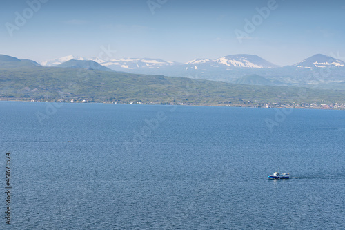 Ferry boat or fishing ship transporting passengers on Lake Sevan in Armenia. Water cruise and tours concept © EdNurg