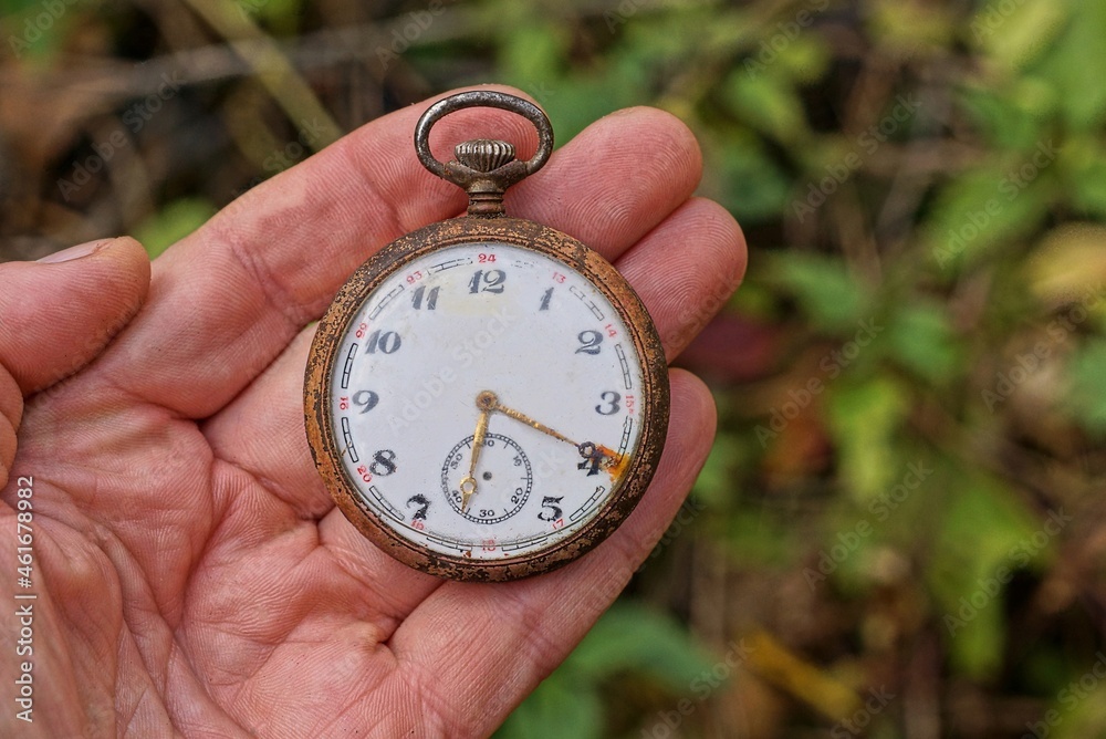 one big round old retro pocket watch lie on the fingers on the hand in the street one big round old retro pocket watch lie on the fingers on the hand in the street
